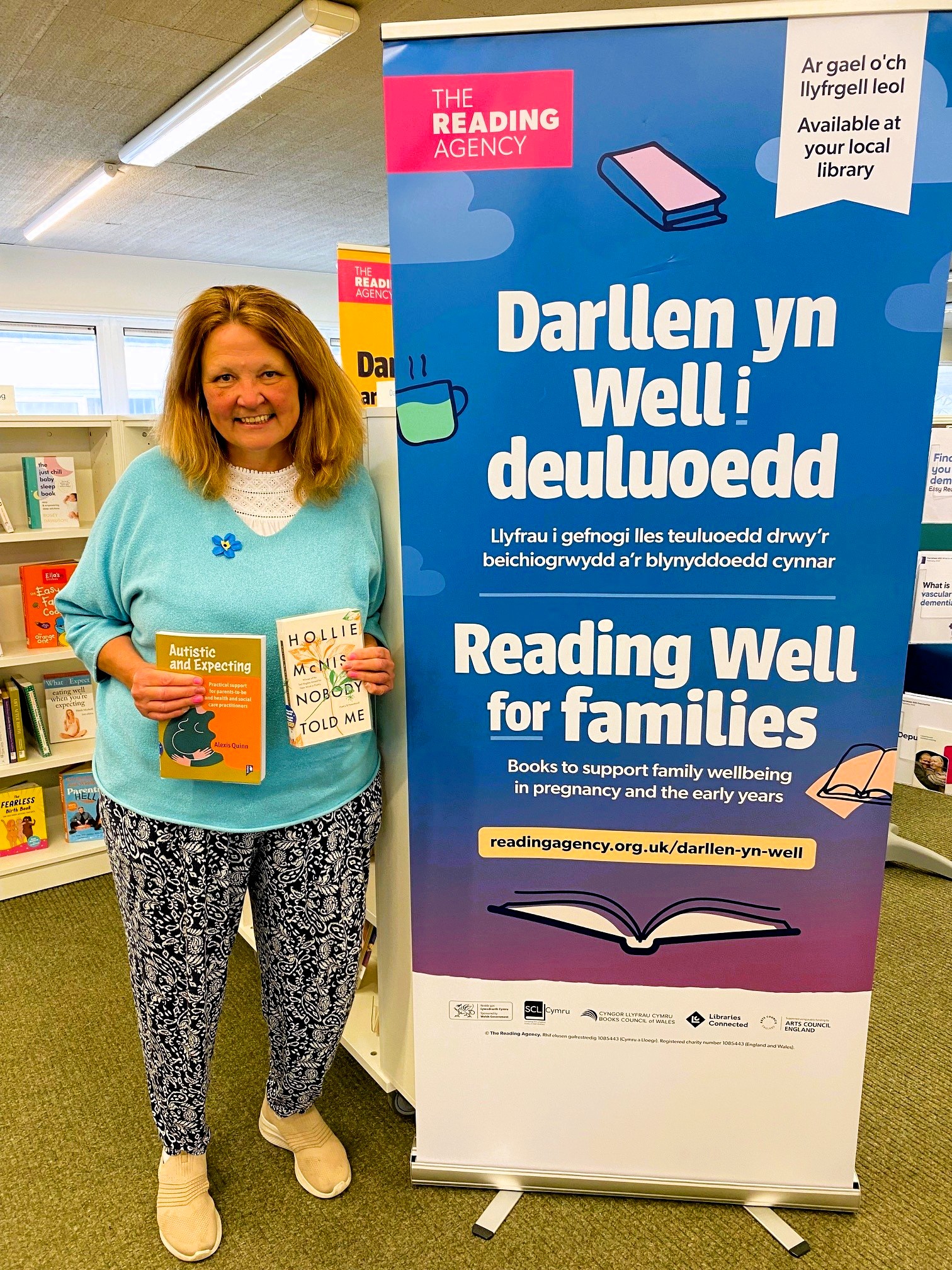 Reading Well for Families display with library staff member holding books