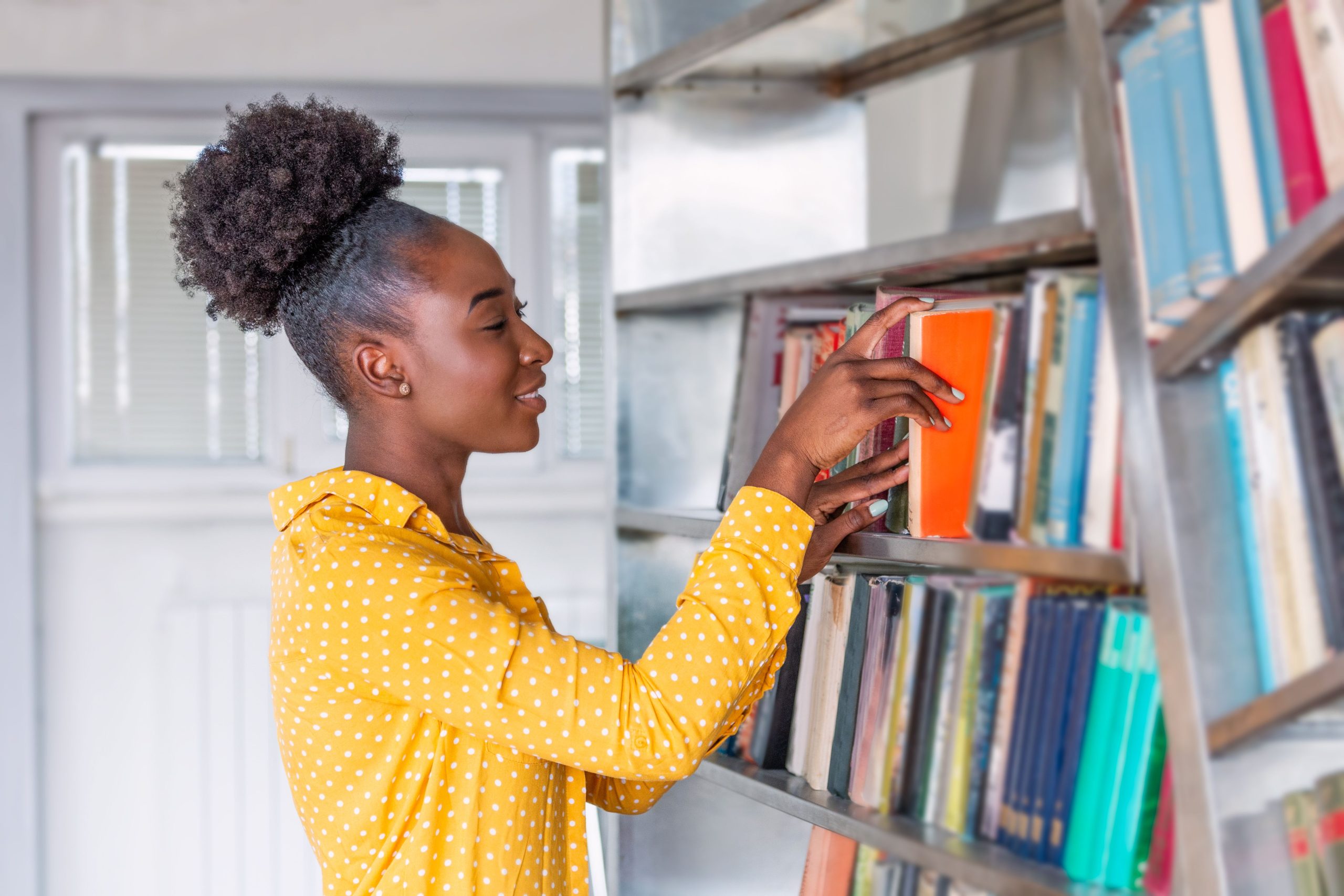 Lady taking a book from the shelf